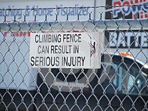 Prohibiting sign on a metal fence protecting a company area in Fort Macleod, Alberta, Canada.