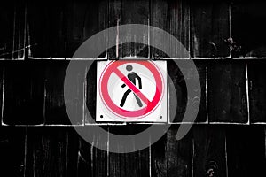 Prohibition No Pedestrian Sign next the fence. Prohibited signs figura of walking man in a crossed circle on black background photo