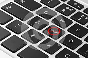Prohibition sign with word Spam on laptop button, closeup. Device keyboard