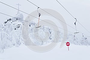 Prohibitory road sign No entry against the background of an empty ski surface lifts on a snowy ski slope