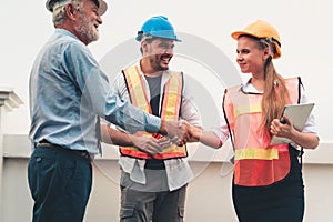 Project management team of engineers and architects are handshake together after dealing their project, Business construction con