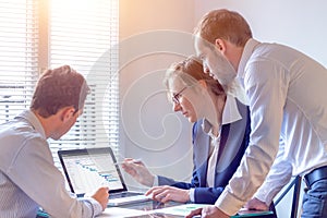 Project manager meeting with team for decision on planning milestones and deliverables, Gantt chart schedule on computer screen, 3