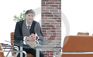 Project manager sitting at a table in an empty conference room