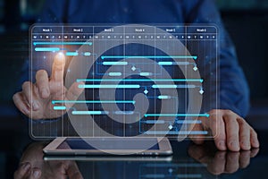 Project manager working with Gantt chart schedule to plan tasks and deliverables. Scheduling activities with planning software.