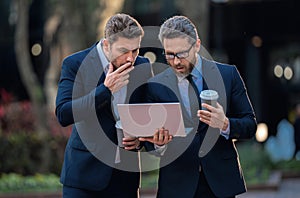 Project planning. Surprized business men team using laptop outdoor. Businessmen looking laptop with their business