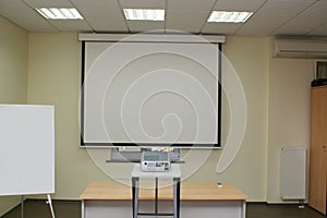 Projection screen in the boardroom with projector on table