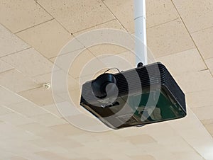 A projector hanging from the ceiling in a room