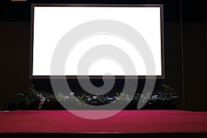 projector screen on stage with red carpet in conference hall.