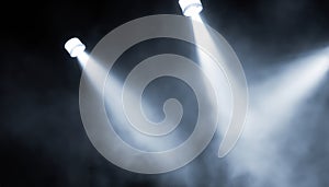 projectors light beam through smoke on stage