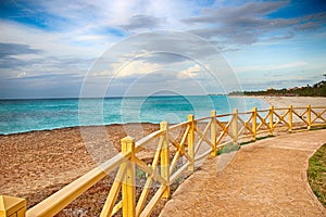 Promenade around the sea with a wooden railing and a view of the water. The clear turquoise sea of the Atlantic ocean on which are