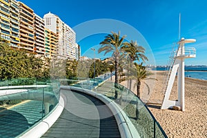 Promenade, buildings and pedestrian bridge along the beach in Alicante, Spain