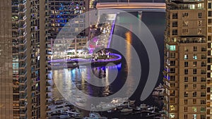 Promenade and canal in Dubai Marina with luxury skyscrapers around night timelapse, United Arab Emirates