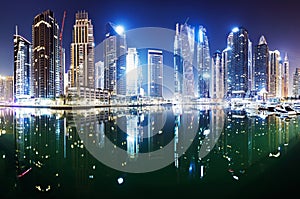 Promenade and canal in Dubai Marina at night with luxury skyscrapers around,United Arab Emirates