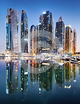 Promenade and canal in Dubai Marina at night with luxury skyscrapers around,United Arab Emirates