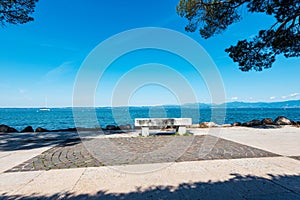 Promenade on the coast of Lake Garda with a Stone Bench - Lazise Veneto Italy