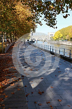 Promenade le long du quai Notre-Dame aÃÂ Tournai en Belgique en automne. Pont des trous en perspective photo