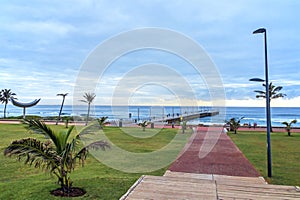 Promenade Leading Toward Pier Beach and Blue Cloudy Skyline