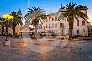 Promenade with street cafes and palm trees at dawn, Trogir photo