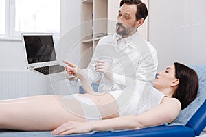Prominent advanced doctor showing possible result of the procedure