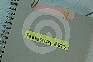 Promissory Note write on sticky notes isolated on Wooden Table