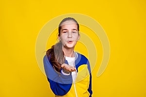 promotion and sale of sports goods, girl in sports wear in Ukrainian flag colors over yellow background