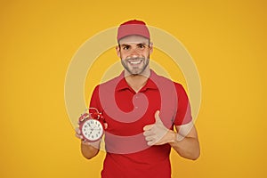 Promptness and punctuality. Delivery time. Delivery courier with clock. Delivery man holding clock. Shipping services photo