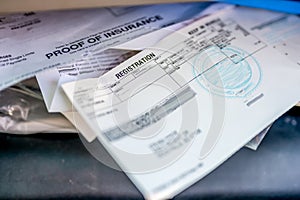 Proof of insurance and vehicle registration documents in the glove compartment of a car.