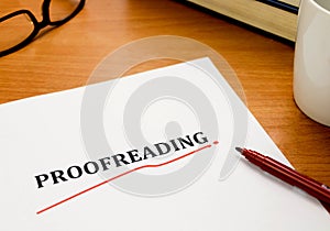 Proofreading word on white sheet with red pen