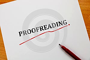 Proofreading word on white sheet with red pen