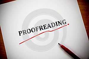 Proofreading word on white sheet with red pen