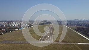 Propeller airplane taking off from airport runway on a sunny day, aerial shot