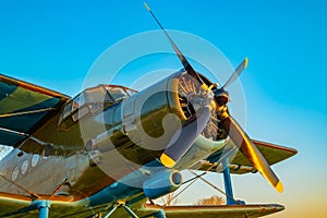 Propeller blades of the engine of an old aircraft with part of the fuselage, cabin and wings in khaki green colors