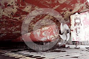 Propeller of cargo ship. Dry dock. View from stern. Rusty. Before repeating work