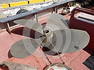 A propeller on the deck of a tug-boat.