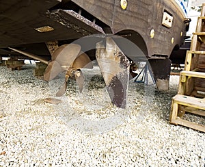 A propeller and rudder on a large sport fishing boat.