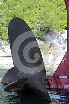 A propeller from a ship stuck on the seashore on a hot summer sunny day.