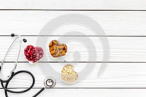 Proper nutrition for pathients with heart disease. Cholesterol reduce diet. Oatmeal, pomegranate, almond in heart shaped