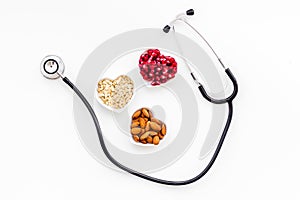 Proper nutrition for pathients with heart disease. Cholesterol reduce diet. Oatmeal, pomegranate, almond in heart shaped