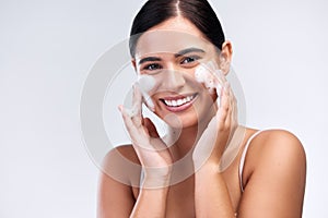 Proper skin care means cleansing it properly. Studio shot of a beautiful young woman washing her face.