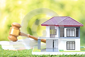 Property auction, Model house and Gavel wooden on natural green background, lawyer of home real estate and ownership property