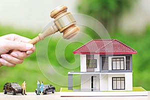 Property auction, Woman hand holding gavel wooden and model house on natural green background, lawyer of home real estate and