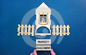 Property investment symbol. Concept words Property investment on beautiful wooden blocks. Wooden model of house. Beautiful grey