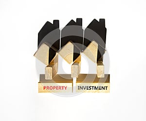 Property investment symbol. Concept words Property investment on beautiful wooden blocks. Wooden model of houses. Beautiful white