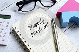 Property investment written on a notebook. Business and finance concept