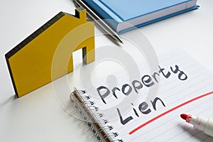 Property lien. Small house and writing in a notebook. photo
