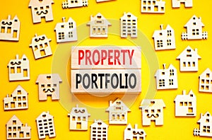 Property portfolio symbol. Concept words Property portfolio on beautiful wooden blocks. Wooden model of houses. Beautiful yellow