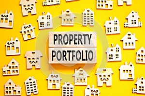 Property portfolio symbol. Concept words Property portfolio on beautiful wooden blocks. Wooden model of houses. Beautiful yellow