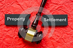 Property settlement concept. Split tablet and gavel on crumpled paper. photo