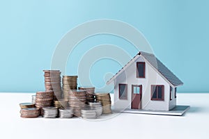 Property tax.investment planning.business real estate. View Of coin stack with house model, mortgage loading real estate property