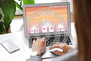 Property value concept. Woman working with laptop at table, closeup